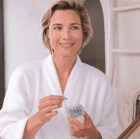 Nu Skin ageloc Tru Face Essence Ultra mit Modell und Dose in der Hand von Nuskin